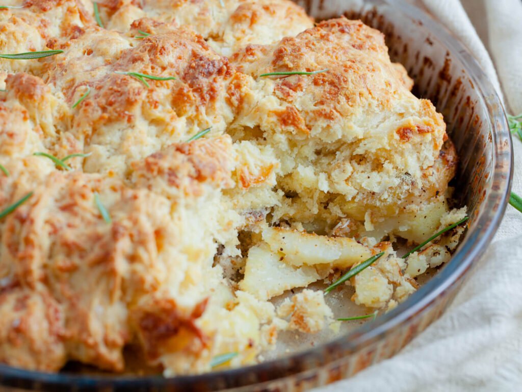 Serve & Enjoy! 🧀Cheesy Potato Cobbler – The Ultimate Comfort Food! -A golden-brown cheesy potato cobbler in a baking dish, with gooey melted cheese on top.