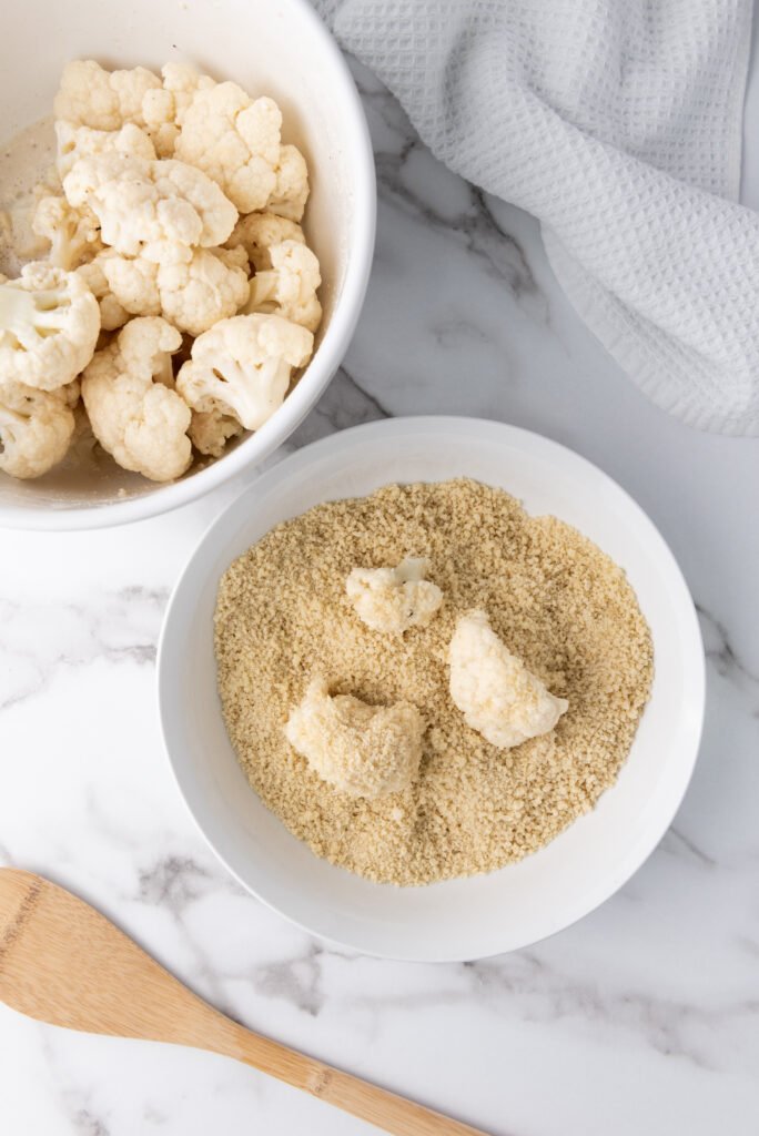 Prep the Cauliflower Wings 🥦-Sweet & Savory Teriyaki Cauliflower Wings – A Crunchy Delight! -A close-up of crispy teriyaki cauliflower wings garnished with sesame seeds and fresh herbs.