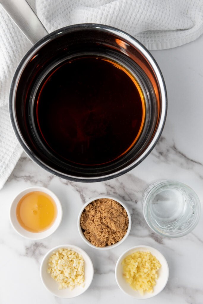 Make the Sticky Teriyaki Sauce 🍯--The Perfect Vegan Treat! - A plate of golden-brown teriyaki cauliflower wings with a glossy, caramelized glaze.