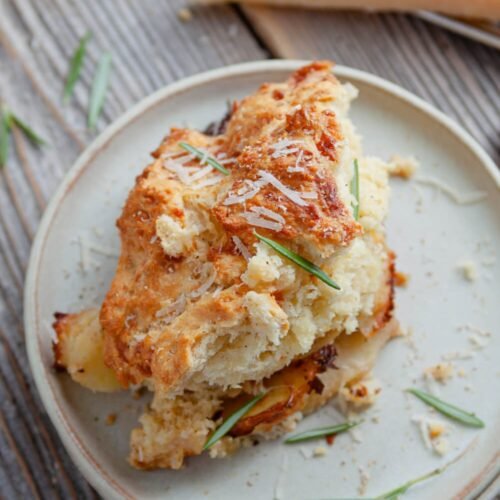 Cheesy Potato Cobbler – The Ultimate Comfort Food! -A golden-brown cheesy potato cobbler in a baking dish, with gooey melted cheese on top.