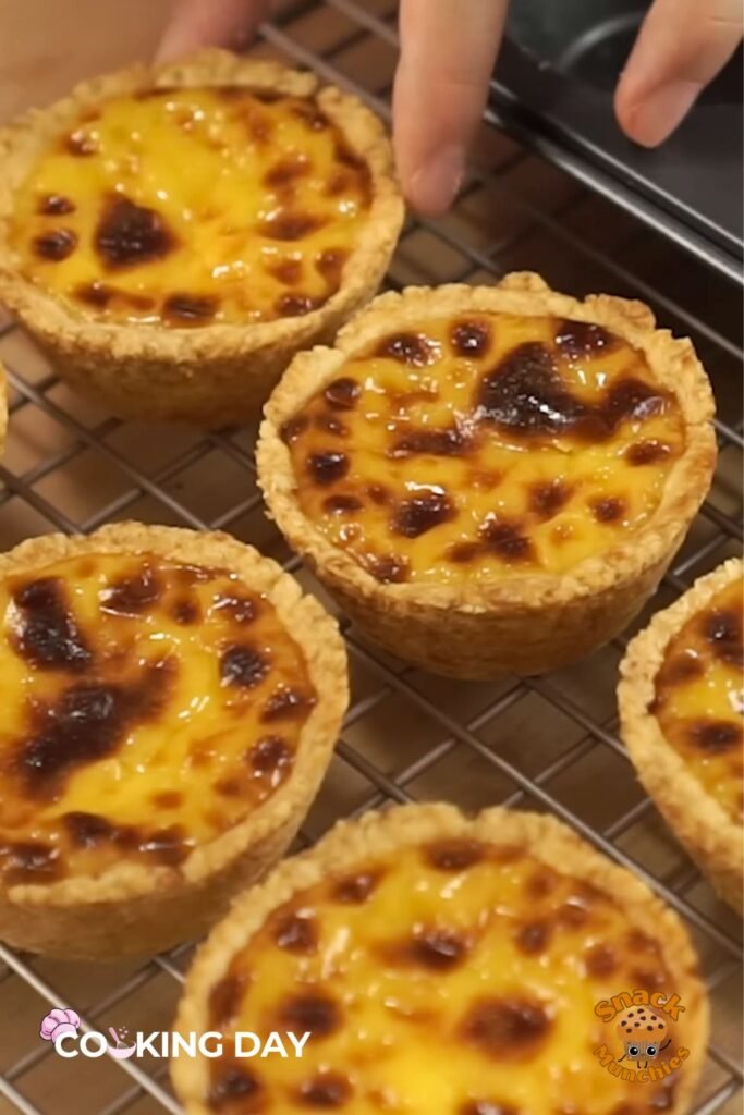 A tray of freshly baked egg tarts with golden edges and smooth, jiggly centers.