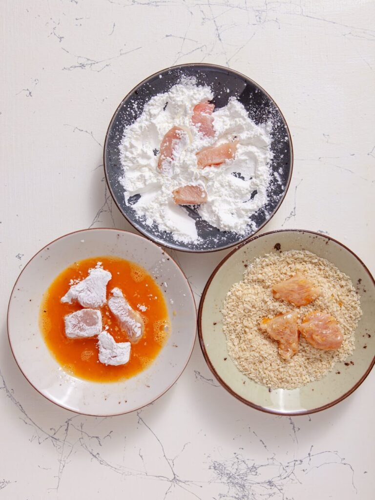 Coating the Chicken with cornstarch, egg, and panko - Easy Baked Orange Chicken 