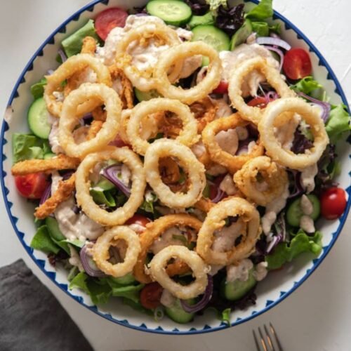 Crispy calamari salad with fresh vegetables and creamy lemon herb dressing