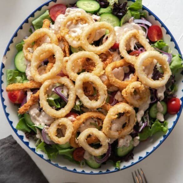 Crispy calamari salad with fresh vegetables and creamy lemon herb dressing