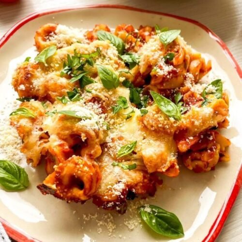 Cheesy baked tortellini casserole with marinara sauce, mozzarella cheese, Parmesan, basil, and parsley
