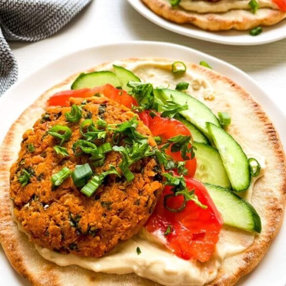 Easy falafel pita burger filled with crispy chickpea patty, hummus, lettuce, tomato, cucumber, and red onion